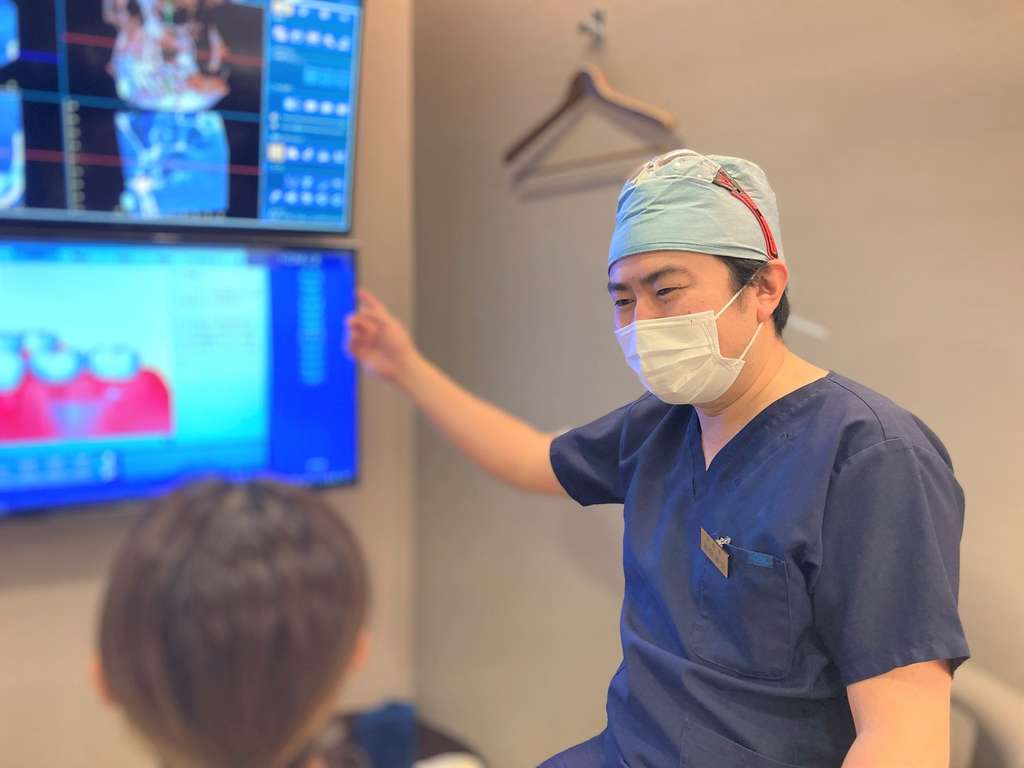 インプラント治療について相談を受ける院長の濱田